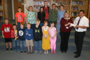 DEFUNIAK SPRINGS MCDONALD’S GENERAL MANAGER ANTONIO PORTUGAL presented a check for $1,000 to Ponce de Leon Elementary School Assistant Principal Tonya McInnis on Wednesday, Dec. 9. The money will go toward paying for the school’s participation in the Accelerated Reader program and other online learning tools. The top readers in grades 1 through 5 were also in attendance at the presentation of the check. Josh Evans, Lillian Sutton, Dylan Baldwin, Noah Hartzog, Samantha Bohannon, Noah Chapman, Sage Galloway, Eli Contreras, Curtis Galloway, Stephanie Strickland, Wyatt Alford, Brianna Archer, and Colby Stapp are pictured. (Photo by Reid Tucker)