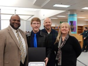WALTON HIGH SCHOOL PRINCIPAL Russell Hughes shares in the celebration of Evan Cowie's latest academic achievement along with his parents, George and Terri Cowie. Evan was named Walton County's Sunshine State Scholar.