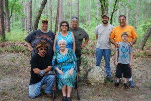 MEMBERS OF THE EXTENDED PADGETT FAMILY take a break next to the grave of Margaret Padgett. The Padgett family once lived on what is now Western Walton County. That area lies within closed areas of Eglin reservation and the family has to get special permission to visit their old home place and family cemetery. Very little exists of the home place but family members have kept the cemetery cleaned up on annual trips to the remote site. To do so they are escorted by personnel from Jackson Guard. (Photo by Jeffrey Powell)