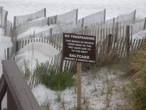 "NO TRESPASSING" sign placed by beachfront property owners near a walkway to the beach in the Gulf Trace subdivision.