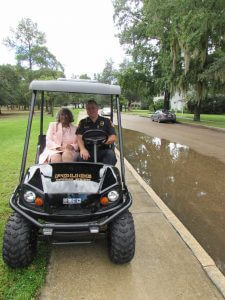 THE SUN BROKE THROUGH just long enough for DeFuniak Springs City Marshal Mark Weeks to escort Ms. Wilkerson down Circle Drive to her "Woman of Light" commemorative stone. Wilkerson was honored Aug. 12. (Photo by Elizabeth Sinclair)