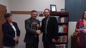 WALTON COUNTY SCHOOL BOARD CHAIR JASON CATALANO presents Mark Davis with a plaque from the district celebrating his 21 years of service to the district.